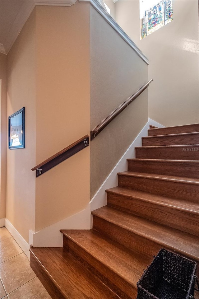 staircase featuring tile patterned floors and baseboards