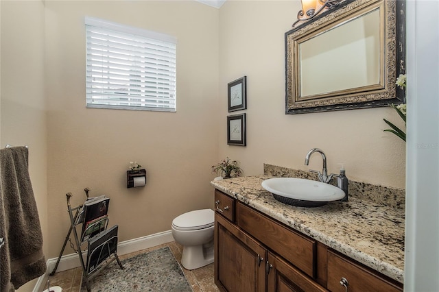 bathroom featuring tile patterned flooring, toilet, vanity, and baseboards