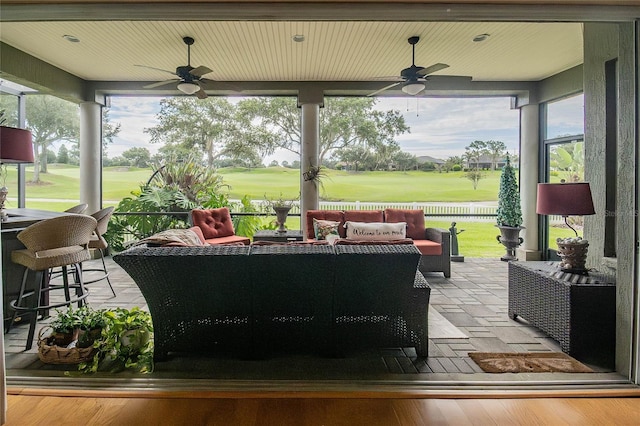 view of patio / terrace with golf course view, a ceiling fan, outdoor lounge area, and fence