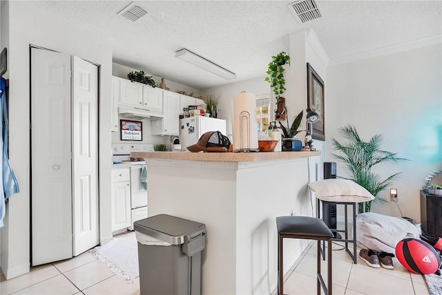 4255 Summer Landing Dr Unit 106, Lakeland, FL 33810 - kitchen with white cabinets, visible vents, light tile patterned flooring, and white appliances