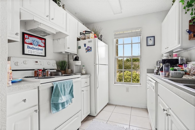 kitchen with a textured ceiling, white appliances, light tile patterned floors, and white cabinets