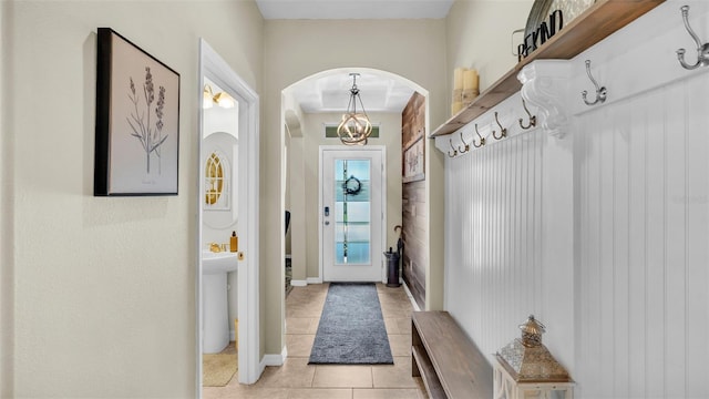 mudroom with light tile patterned floors, visible vents, and arched walkways