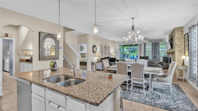 kitchen with a center island with sink, white cabinets, dishwasher, open floor plan, and a sink