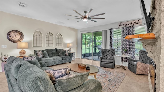 living room featuring light tile patterned floors, baseboards, visible vents, and a ceiling fan