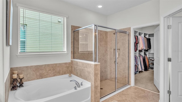 full bath featuring a stall shower, a walk in closet, a bath, and recessed lighting