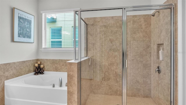 bathroom with a garden tub, plenty of natural light, and a shower stall