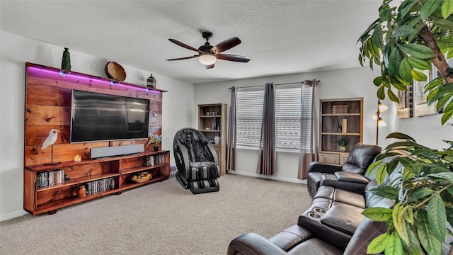 living area with a ceiling fan, light colored carpet, a textured ceiling, and baseboards