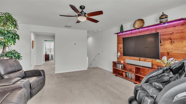 living room with a textured ceiling, ceiling fan, visible vents, and baseboards