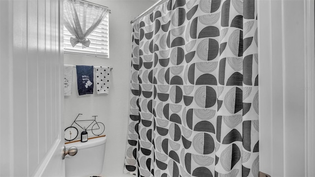 full bathroom featuring a shower with curtain and toilet