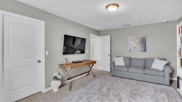 living area featuring light carpet, a textured ceiling, visible vents, and baseboards