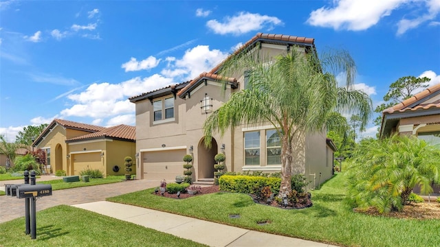 mediterranean / spanish-style house featuring a tiled roof, a front lawn, decorative driveway, and stucco siding