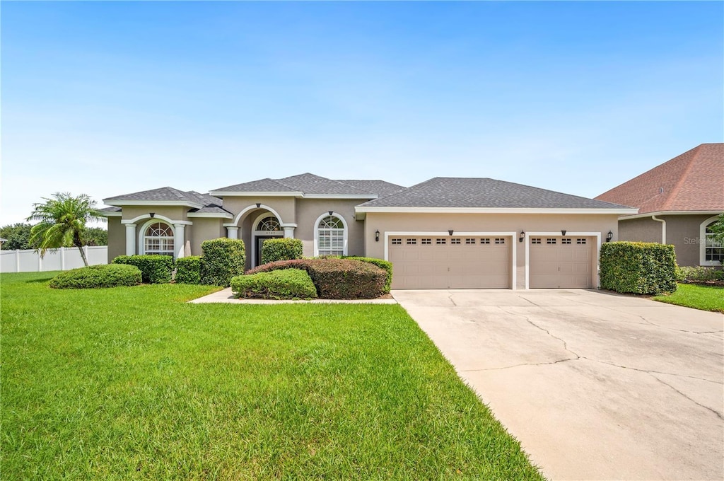 view of front of home featuring a garage and a front lawn