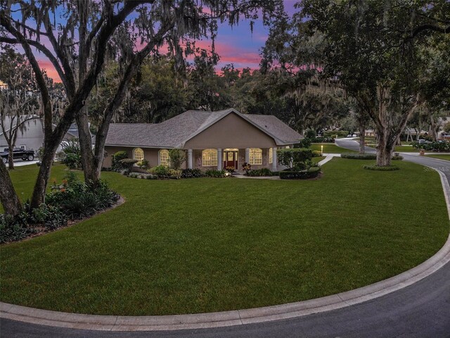 ranch-style home with a lawn