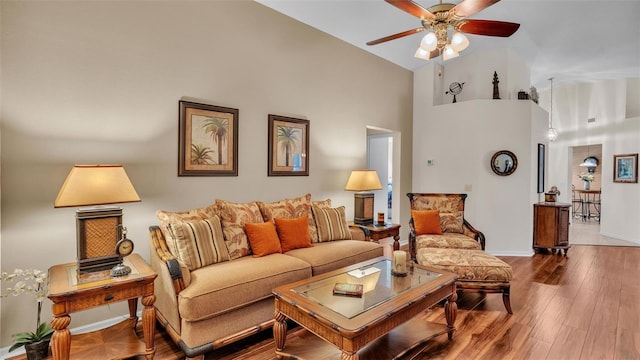 living room featuring high vaulted ceiling, hardwood / wood-style floors, and ceiling fan