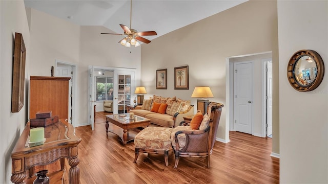 living room featuring french doors, ceiling fan, high vaulted ceiling, and light hardwood / wood-style flooring