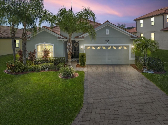 view of front of property with a garage and a lawn