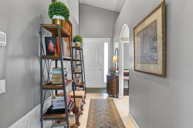 tiled entrance foyer with a towering ceiling