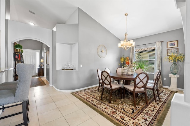 dining room with light tile patterned floors, a chandelier, and vaulted ceiling