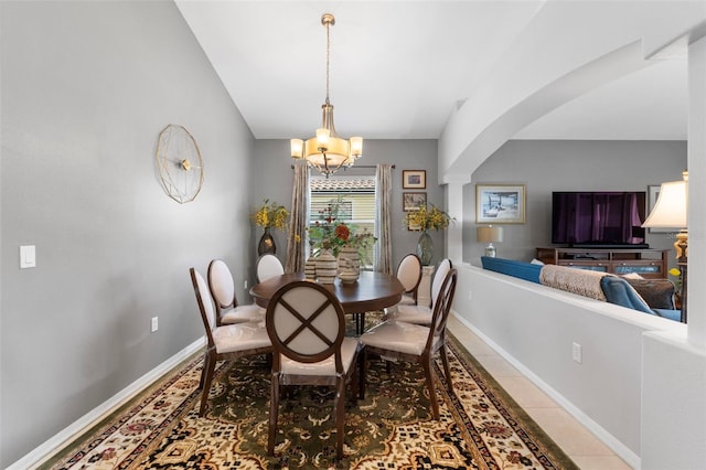 dining space with decorative columns, light tile patterned floors, and an inviting chandelier