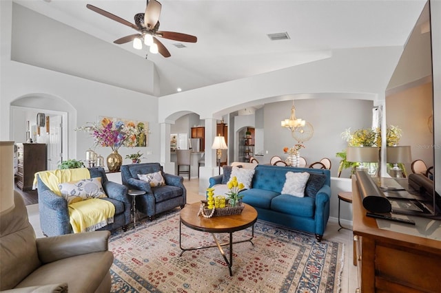 living room with ceiling fan with notable chandelier and lofted ceiling