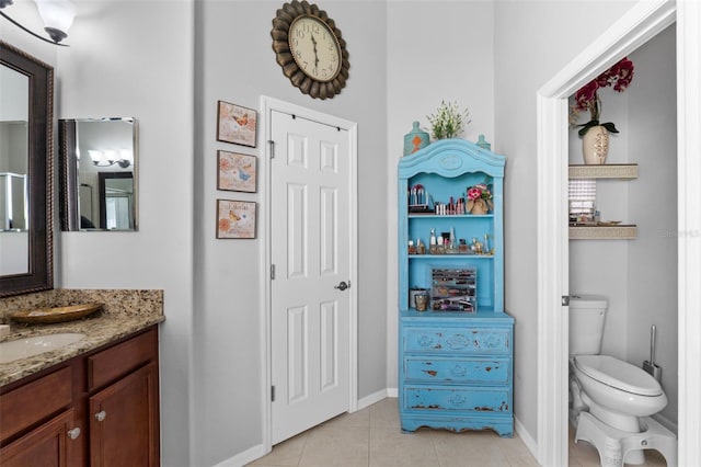 bathroom with toilet, tile patterned flooring, and vanity