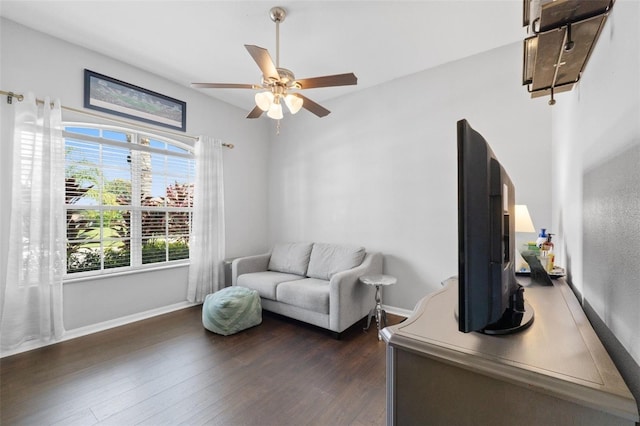 living room featuring ceiling fan and dark wood-type flooring