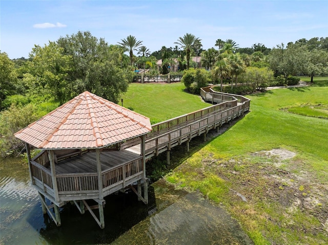 view of home's community with a water view and a yard