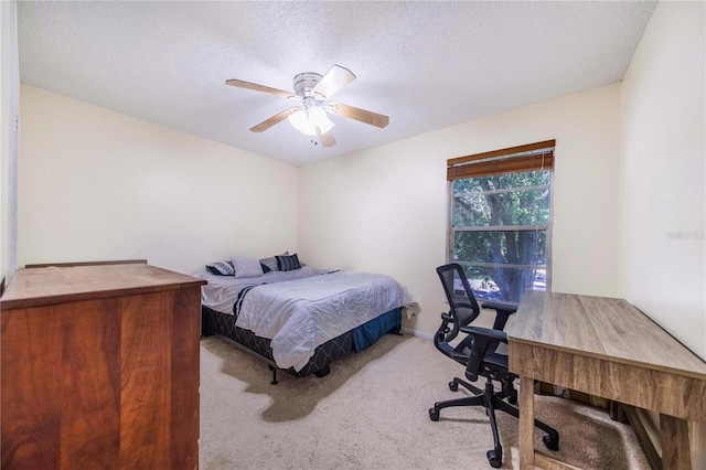 bedroom featuring ceiling fan, light carpet, and a textured ceiling