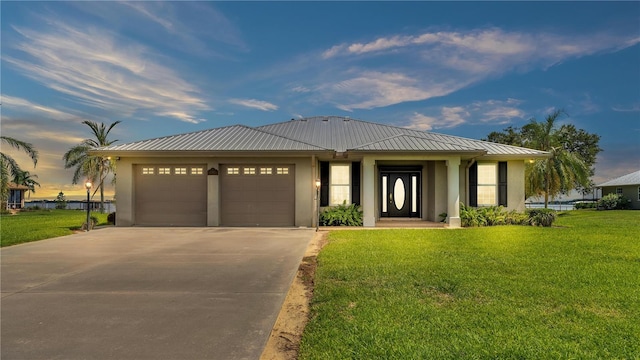 view of front of property featuring a garage and a yard