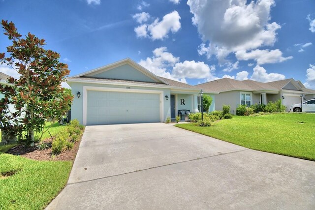 ranch-style home featuring a garage and a front lawn