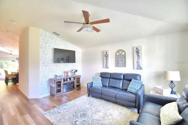 living room with vaulted ceiling, ceiling fan, and light hardwood / wood-style floors