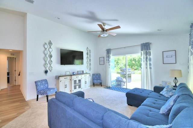 carpeted living room with high vaulted ceiling and ceiling fan