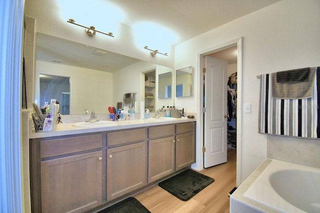 bathroom featuring vanity, hardwood / wood-style floors, and a bathtub