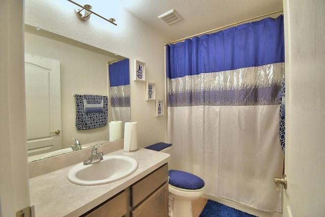 bathroom with vanity, curtained shower, and toilet