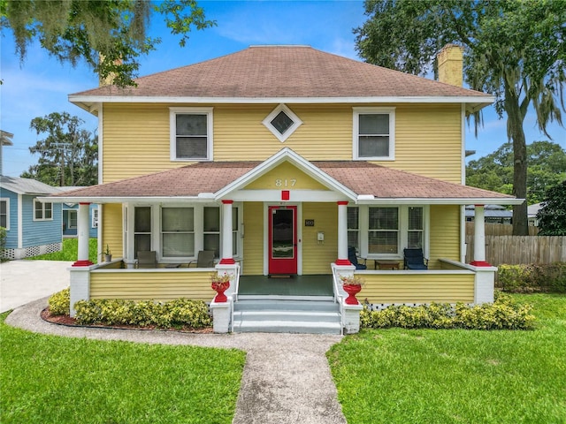 view of front facade with covered porch and a front lawn