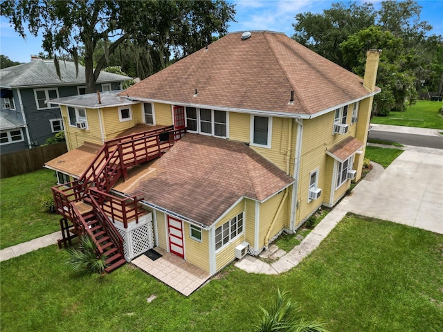 rear view of property featuring a wooden deck, a yard, and cooling unit