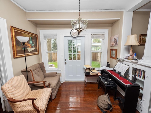 living area featuring dark hardwood / wood-style flooring, a notable chandelier, and ornamental molding