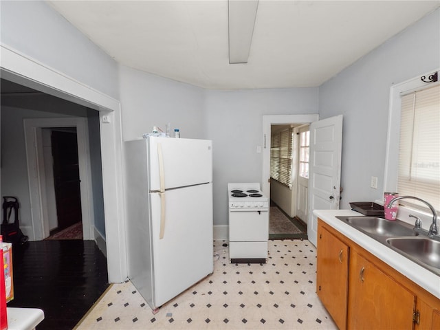 kitchen with white appliances, plenty of natural light, and sink