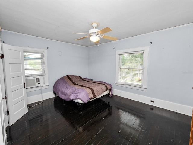 bedroom with cooling unit, dark hardwood / wood-style flooring, multiple windows, and ceiling fan