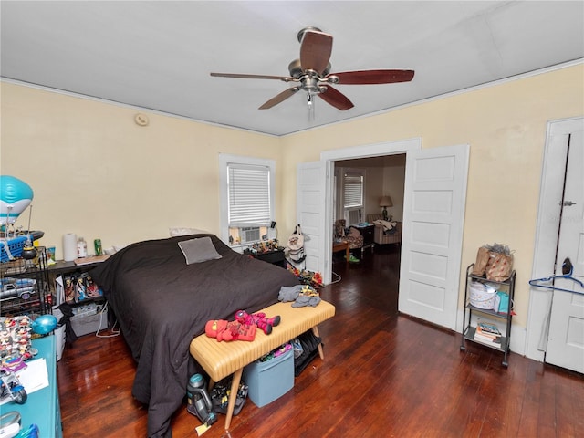bedroom featuring cooling unit, ceiling fan, and dark hardwood / wood-style floors