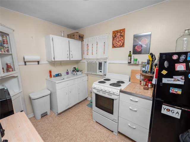 kitchen featuring electric stove, sink, white cabinetry, and black fridge