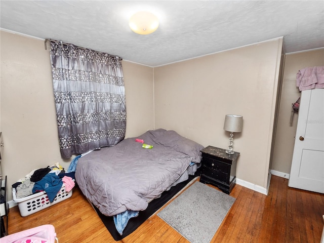 bedroom featuring hardwood / wood-style flooring and a textured ceiling