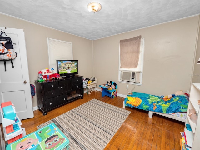 rec room featuring hardwood / wood-style floors, cooling unit, and a textured ceiling