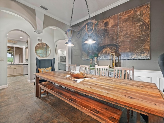 dining room with visible vents, arched walkways, and crown molding