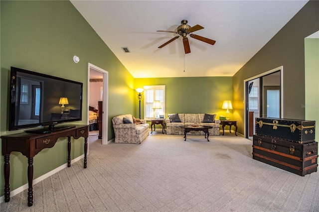 living room with ceiling fan, lofted ceiling, and carpet