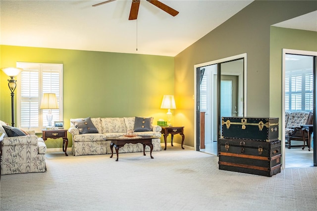 carpeted living room featuring lofted ceiling, ceiling fan, and a wealth of natural light