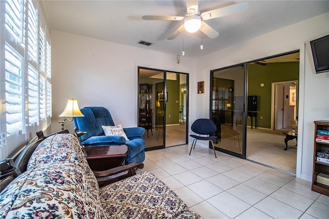 living room featuring light tile patterned floors and ceiling fan