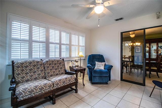 tiled living room featuring ceiling fan with notable chandelier