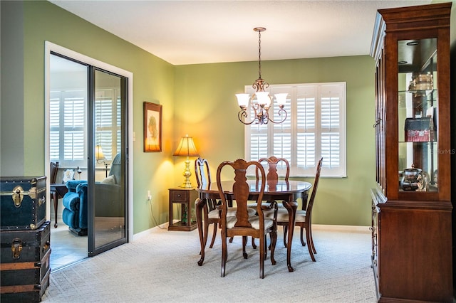 carpeted dining area featuring a chandelier