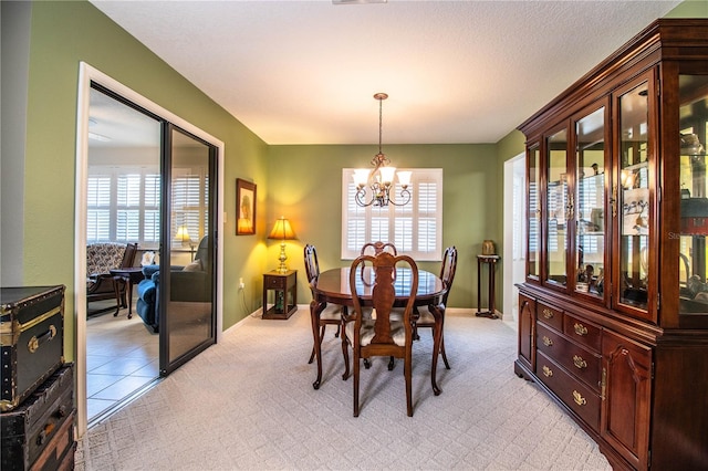 dining room featuring a notable chandelier and light colored carpet